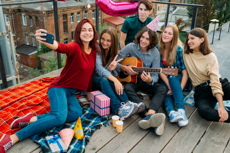 Birthday group selfie on a rooftop. Friends taking photo to share in social networks. Youth bff lifestyleの写真素材