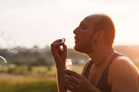Man bubble blowing portrait nature concept. Unity with the nature. Traveler leisure.の写真素材