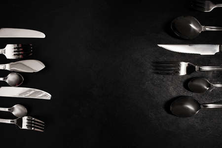 Silver cutlery on black background. food etiquette conceptの写真素材
