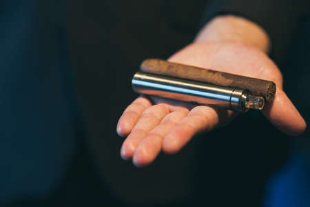 Healthy alternative to tobacco. Cigar against e-cigarette. Man has a choice between traditional and modern way of smoking.の写真素材