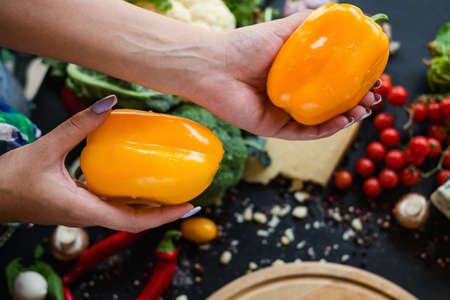 Woman hands holding sweet yellow peppers. Eco market vegetable choice. Organic agriculture.