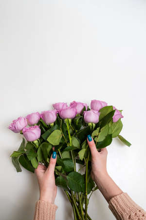 Women hands holding a beautiful bunch of pink roses on white backgroundの写真素材