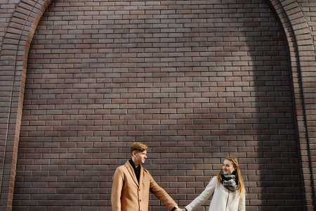 Young adults in romantic relationship. Couple holding hands on a date. Happy together. Free space...
