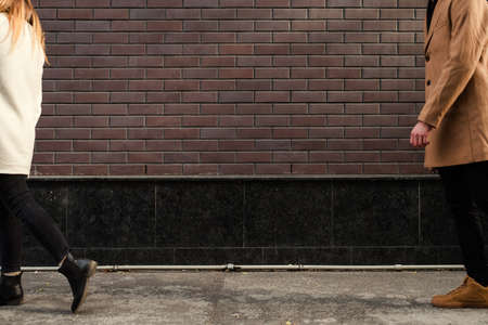Couple breakup. Girl leaving. Love end. Loss sadness. Broken heart. Conflict problems concept. Brick wall free space backgroundの写真素材