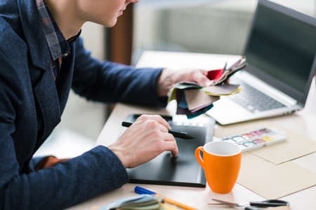 fashion designer sketching on graphic tablet. Creation of new clothes collection. Unique craft,...