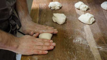 chef cooking dough dumplings or halusky. Preparing meals at professional kitchen. Traditional...