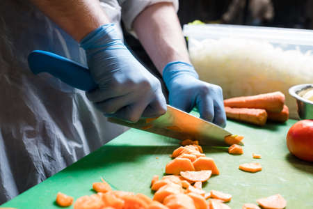 Meal preparation process. Chef cutting carrot. Healthy vegetable dish recipeの写真素材