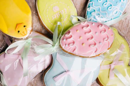 easter gingerbread cookies in colorful glazing mix background. holiday pastry foodの写真素材