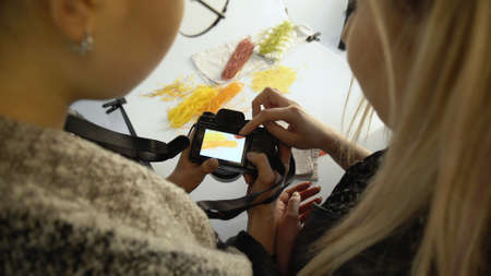 backstage photography. teamwork ideas brainstorming communication. photographer and assistant reviewing photos. camera equipment.の写真素材