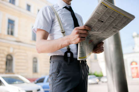 information mass media. daily business news. urban lifestyle. office worker reading newspaper on his way to work. morning press screeningの写真素材