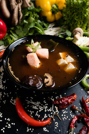 fish tofu and mushroom soup in a bowl on dark background. oriental cuisine food. traditional meal.の写真素材