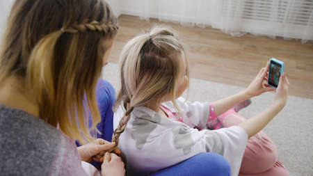friends bff leisure communication. hair braiding and selfie. girls beauty partyの写真素材