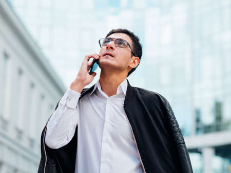 business contacts. man talking on the phone outside. busy lifestyle. city life