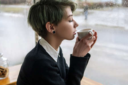 coffee or tea delight. woman enjoying a cup of hot drink. girl treating herself to a delicious hot beverageの写真素材