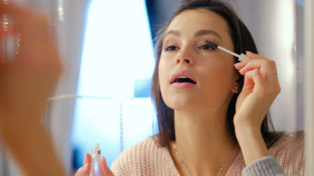 beauty makeup vogue glamour fashion lifestyle. young beautiful girl applying mascara to eyelashes in...