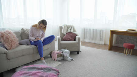 teenage leisure. young adults relaxed lifestyle. girl sitting on the sofa writing in her diary.の写真素材
