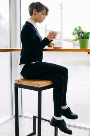 coffee break. young beautiful office worker or business woman sitting at cafe drinking hot beverage.