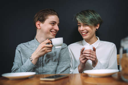 couple love relationship. girlfriend and boyfriend drinking coffee in a bar. talking and laughing on a dateの写真素材