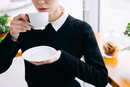 coffee break. office worker or business woman at cafe drinking hot beverage from a white cup
