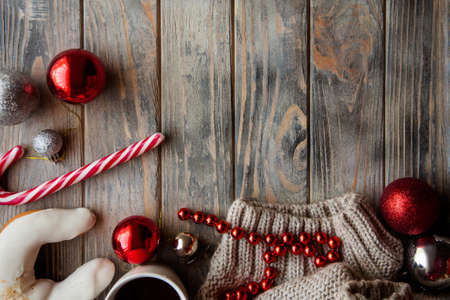 festive cozy christmassy atmosphere. holiday decor on wooden background. baubles candy cane and knitted sweater.の写真素材