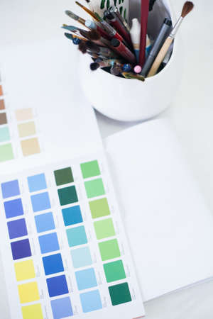 Professional makeup artist tools. Top view of color swatch and set of brushes and pencils.