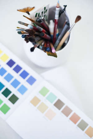 Beautician essential instruments. Top view of color swatch and set of brushes and pencils.の写真素材