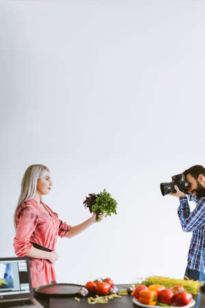 Professional food photography. Studio shooting. Woman with fresh herbs posing on white background.の写真素材