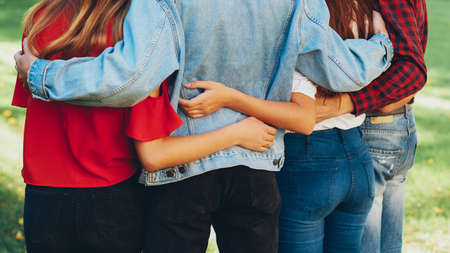 True friendship. Care support happiness. Men women standing hugging in nature park.の写真素材
