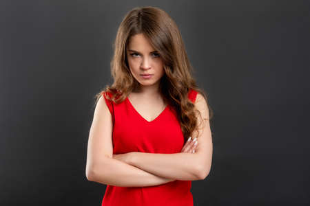 Offended woman portrait. Irritation disappointment. Unhappy lady in red with crossed arms isolated...