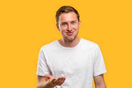 Astonished man portrait. Unbelievable news. Shocked guy raising hand isolated on orange background.の写真素材