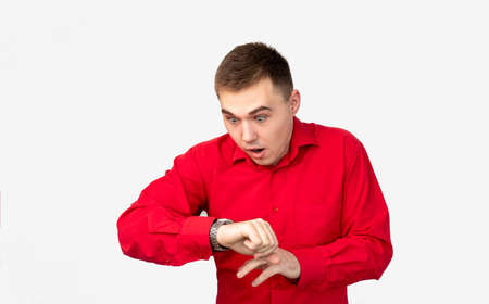 Time is up. Appointment deadline. Anxious man in red shirt late looking at watch isolated on white background.の写真素材