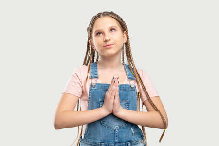 Dreaming girl portrait. Hope faith. Inspired kid praying isolated on neutral background.の写真素材