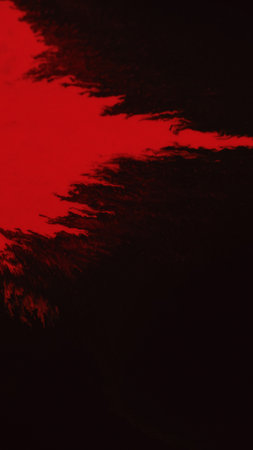 Red paint on black ink flow fluid splash drip darkの写真素材