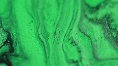 Glitter ink liquid. Oil fluid flow. Defocused neon green black color drip paint emulsion gloss particles wave motion abstract art background.の写真素材
