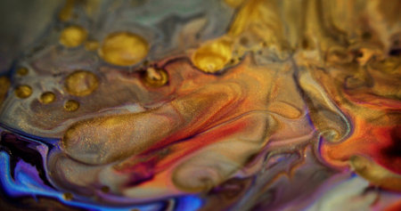 Shiny fluid mix. Glitter paint flow. Defocused red purple yellow color shimmering golden sand...