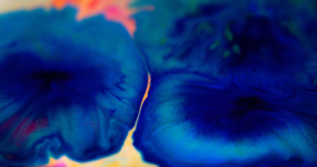 Ink blot. Shiny fluid drip. Defocused blue color sparkling glitter particles water dye paint liquid spill acrylic stain in flower shape abstract art background.の写真素材
