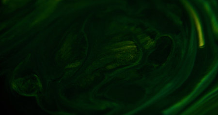 Sparkling paint spill. Acrylic fluid mix. Defocused green black color shimmering grain particles emulsion liquid ink pigment flow abstract art background.の写真素材
