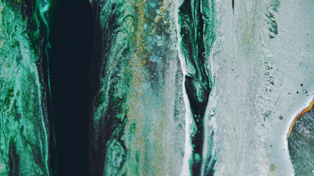 Ink drip. Glitter liquid spill. Blur black green blue golden color shiny glowing particles texture paint wave abstract art background.の写真素材