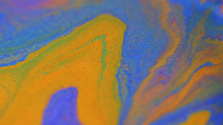 Ink spill. Liquid shimmer texture. Defocused purple orange golden color shiny glitter sand particles paint mix acrylic fluid emulsion flow abstract art background.の写真素材