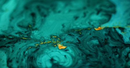 Ink spill. Glitter fluid mix. Defocused cyan blue green black golden color glowing sparkling marble texture acrylic wave abstract art background.の写真素材