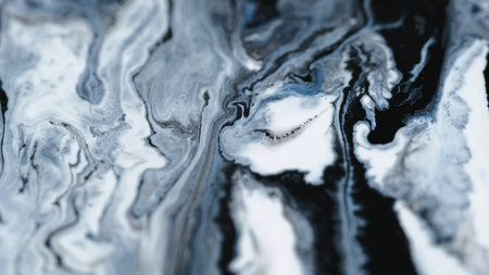Liquid marble texture. Shiny ink mix. Defocused black white gray color sparkling glitter dust particles acrylic fluid paint layers swirl flow abstract art background.の写真素材