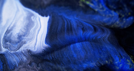 Shimmering spill. Glitter ink flow. Defocused blue white black color shiny texture acrylic paint...