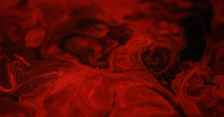 Glitter ink splash. Fluid spill. Defocused red black color shiny particles texture liquid mix...