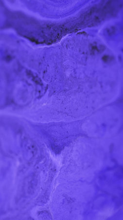 Acrylic fluid spill. Ink liquid wave. Defocused purple black color pigment dust particles dye water...