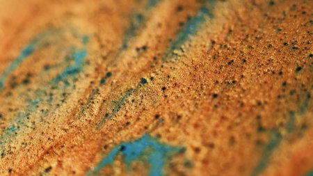 Golden spill. Glitter wave. Defocused orange bronze blue color shimmering particles texture paint stream flow bokeh light abstract art background.の写真素材