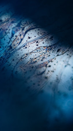 Fizzy fluid texture. Acid liquid. Defocused blue orange color oil emulsion leak puddle slick on dark black light flare abstract art background.の写真素材