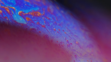 Blur psychedelic fluid. Paint mix. Defocused neon purple orange blue color spectrum oil dye droplets...