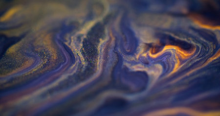 Glitter fluid splash. Blur ink mix. Defocused blue yellow color glowing shimmering texture paint blend flow swirl abstract art background.の写真素材