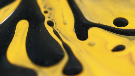 Blur gel bubbles. Sparkling fluid. Defocused yellow black color shiny glowing particles viscous oil spill drip texture paint ink water mix on abstract art background.の写真素材