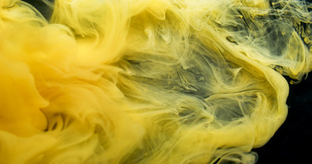 Mist wave. Fog ink swirl. Yellow paint blending in art defocused fluid. Stream color pigment curl explosion abstract black background.の写真素材